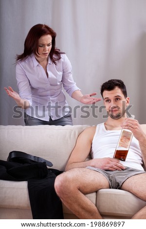 Husband drinking whiskey and ignoring his talking wife