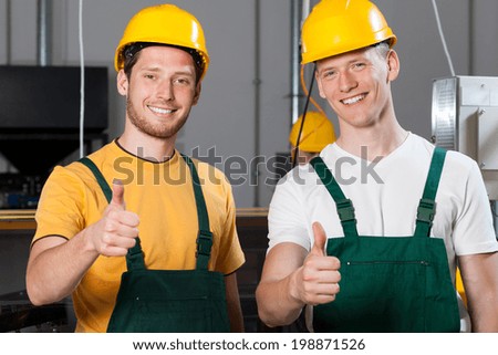 Happy production workers showing thumbs up sign
