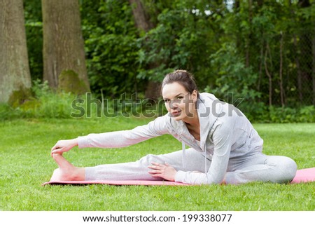 Woman stretching her legs on the open air