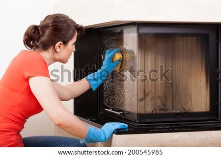 Horizontal view of housekeeper cleaning the fireplace