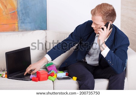 Multitasking man - father and businessman during work