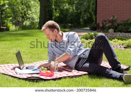 Businessman working in the garden and eating lunch