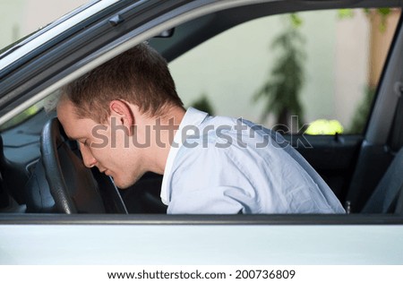 Car accident man with his head on steering wheel
