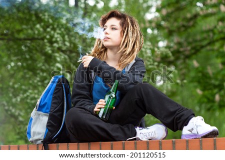 Rude girl smoking marijuana and drinking beer out of school