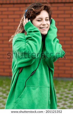Young girl with dreads listening music outside