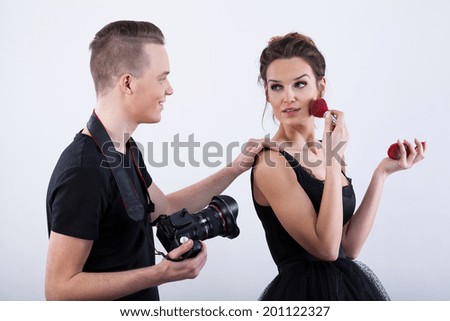 Fashion model adjusting her make-up during break at photo session