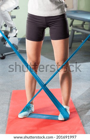 Close-up of woman\'s leg during exercising with yoga belt