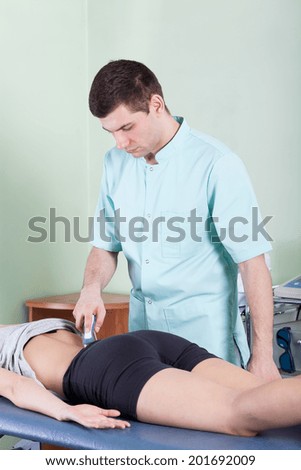 Vertical view of a treatment of back pain by laser therapy