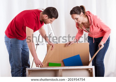Couple packing their things to huge box
