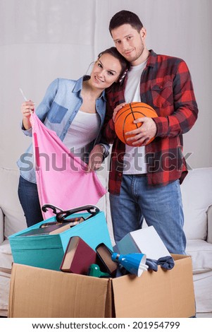 Young happy couple packing things to moving house