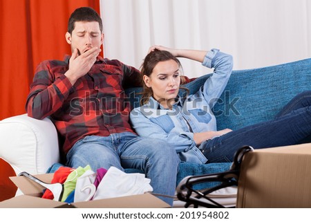 Young marriage sitting on the sofa exhausted of moving house