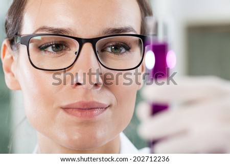 Close-up of a woman holding a test tube with chemicals