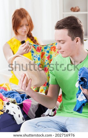 Girl and boy choosing clothes for vacation