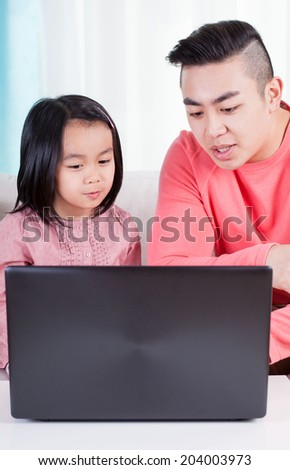 Asian family playing on the computer, vertical