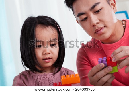 Asian dad having fun with his daughter