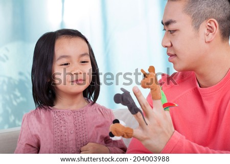Asian family having fun with hand puppets