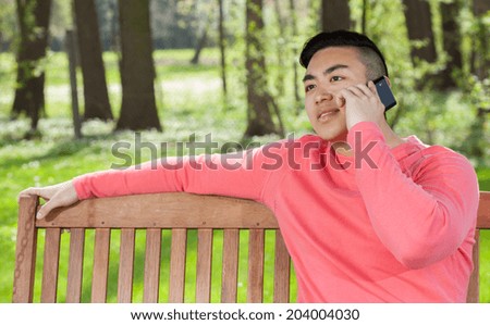 Asian man talking on phone in garden