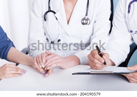 Close-up of a doctor holding patient\'s hand