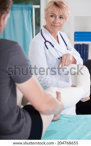 Man with leg in a plaster cast and doctor