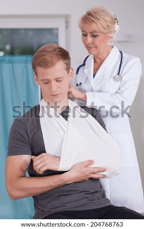 Man with a sling on hand at consulting room