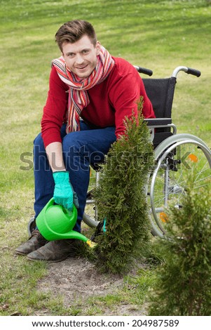 Capable disabled watering flowers in the garden