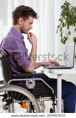 Disabled man using a laptop at home