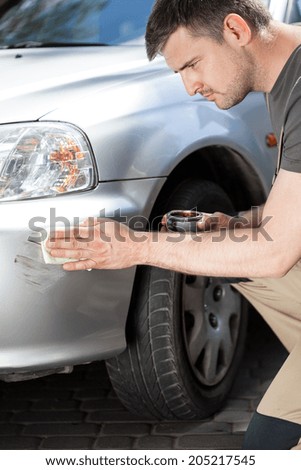 Man applying polish to removing scratches, vertical
