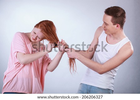 Rude mischevious boy pulling his friend hair