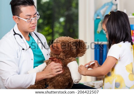 Asian girl caring about bear with her pediatrician
