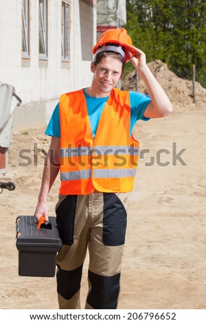 Worker in protective vest and hardhat at construction site