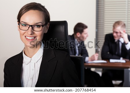 Beautiful businesswoman and co-workers in office, horizontal