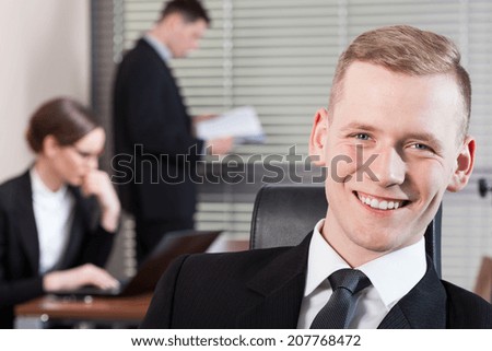 Smiling businessman and his co-workers during work