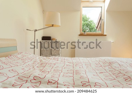View of bright bedroom with small window