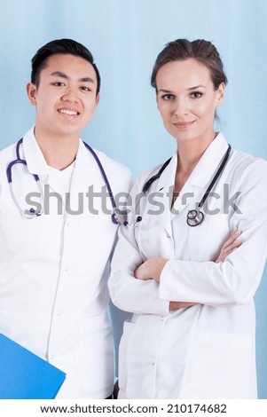 Vertical view of two smiling diverse doctors