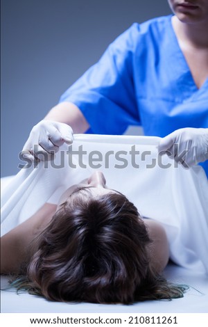 Worker of mortuary covering the dead body of woman