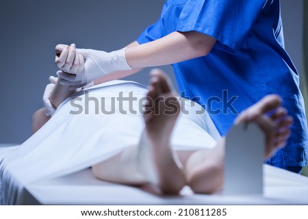 Worker of morgue lying the body of corpse