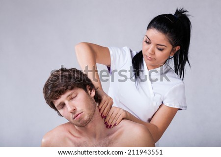 Masseur massaging patient with stiff neck