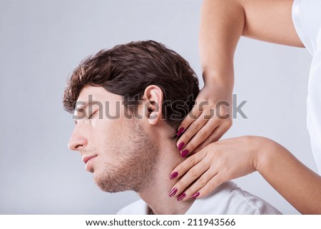 Closeup of physiotherapist palpationing patient with stiff neck