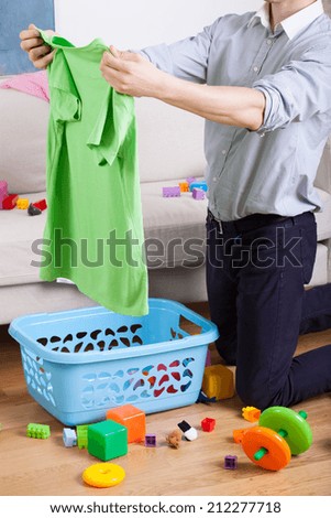 Busy father cleaning and doing laundry at home