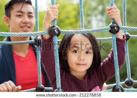 Asian dad and daughter on a playground