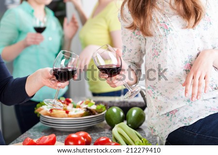 Friends having fun at home with red wine and food