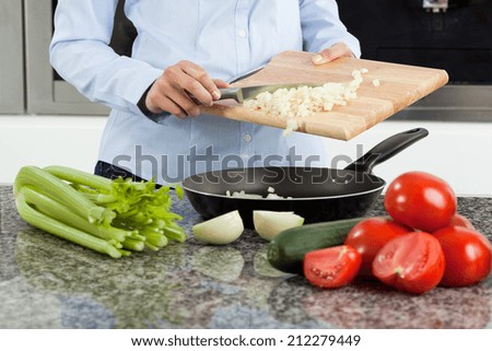 Young woman cooking healthy tasty dinner at home