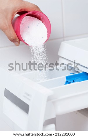 Close-up of pouring washing powder into the washing machine