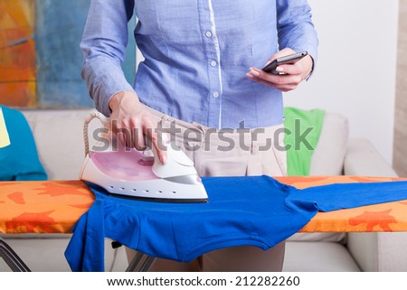 Busy mum during ironing at home, horizontal