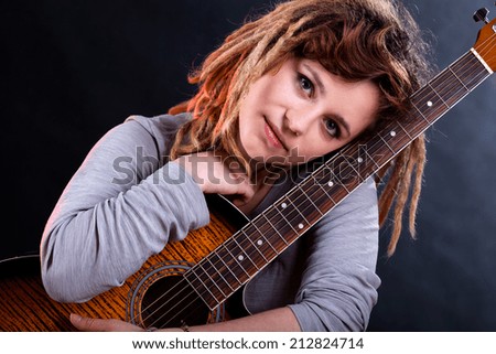 Portrait of a girl with dreadlocks holding guitar