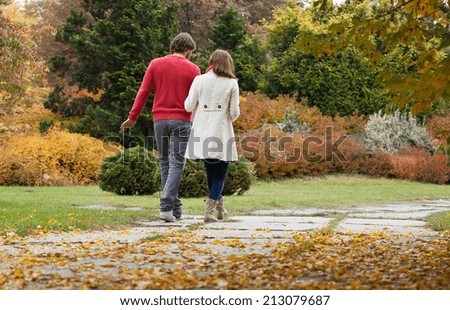 Happy couple in park during autumn walking