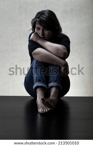 Depressed young woman sitting on the floor