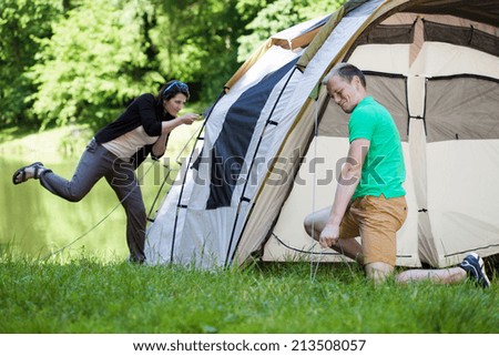 Young couple trying to pitch a tent