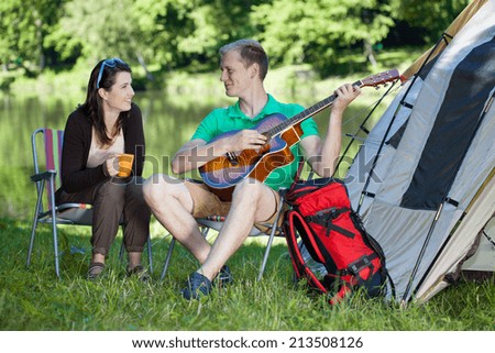 Young woman and man camping over the lake