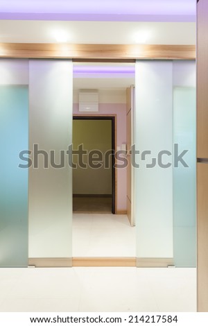 Open illuminated door in modern apartment, vertical